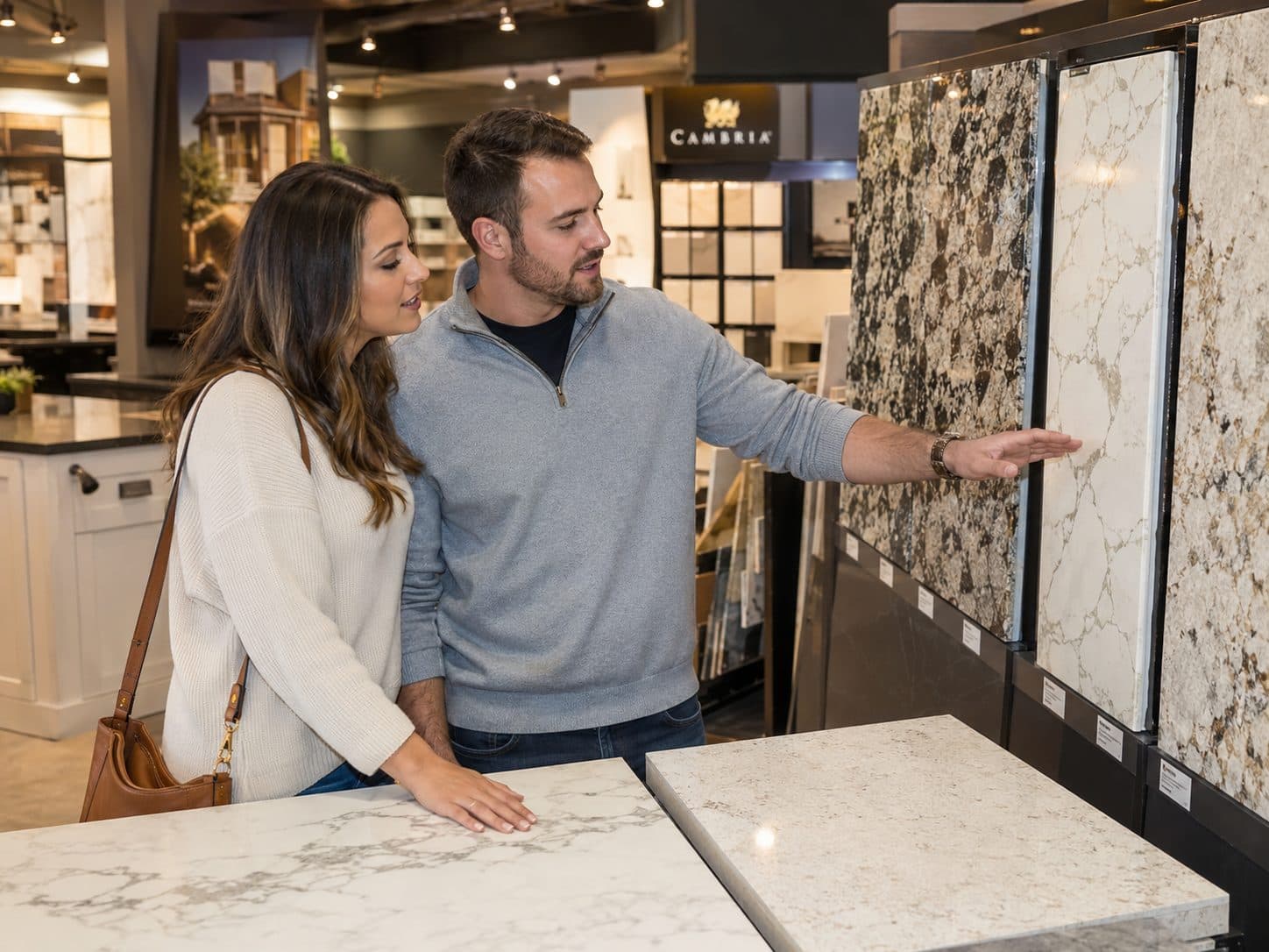 A couple choosing a stone countertop slab in a design showroom