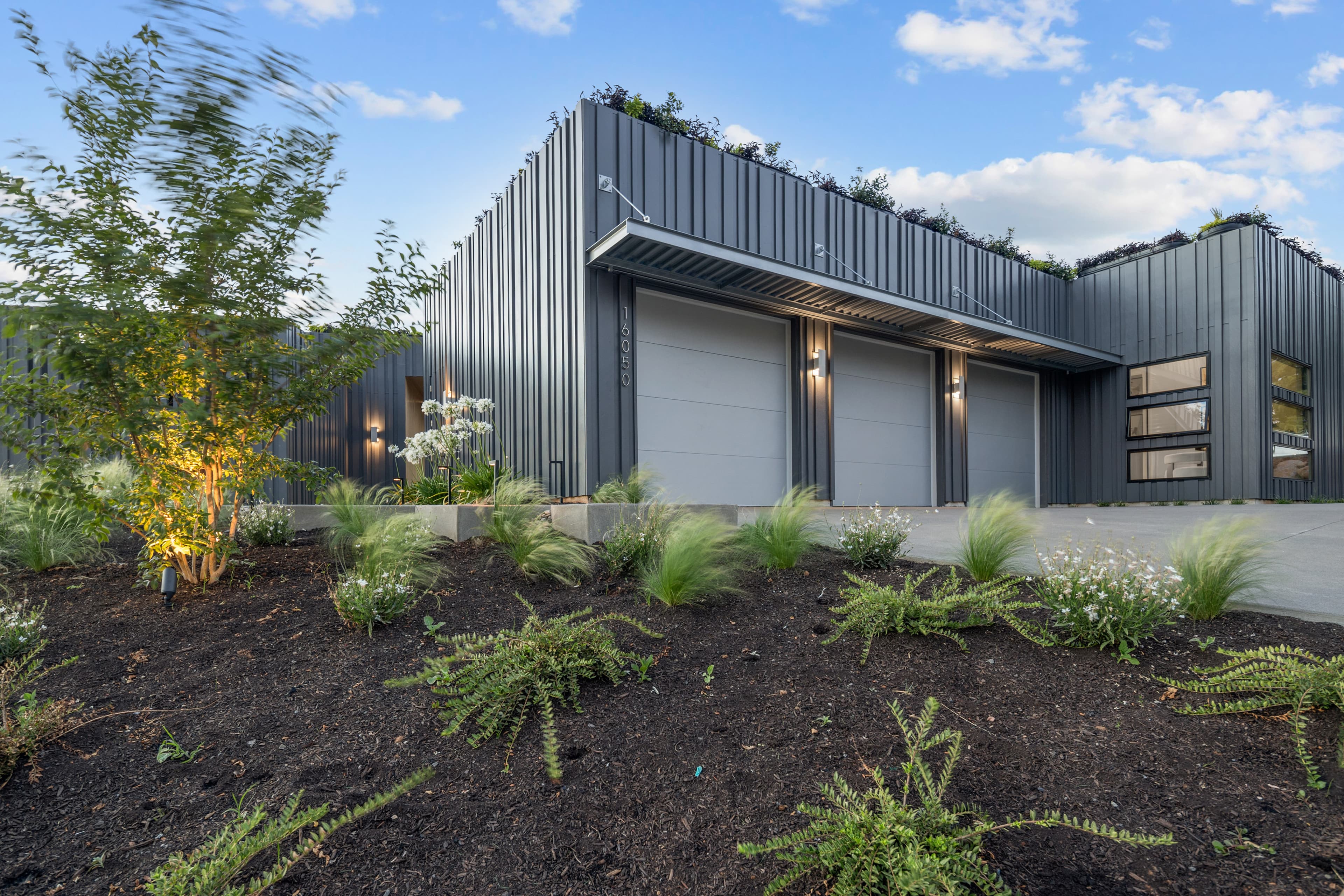 Creekside Homes Street of Dreams custom home exterior — dark vertical batten siding and a living roof