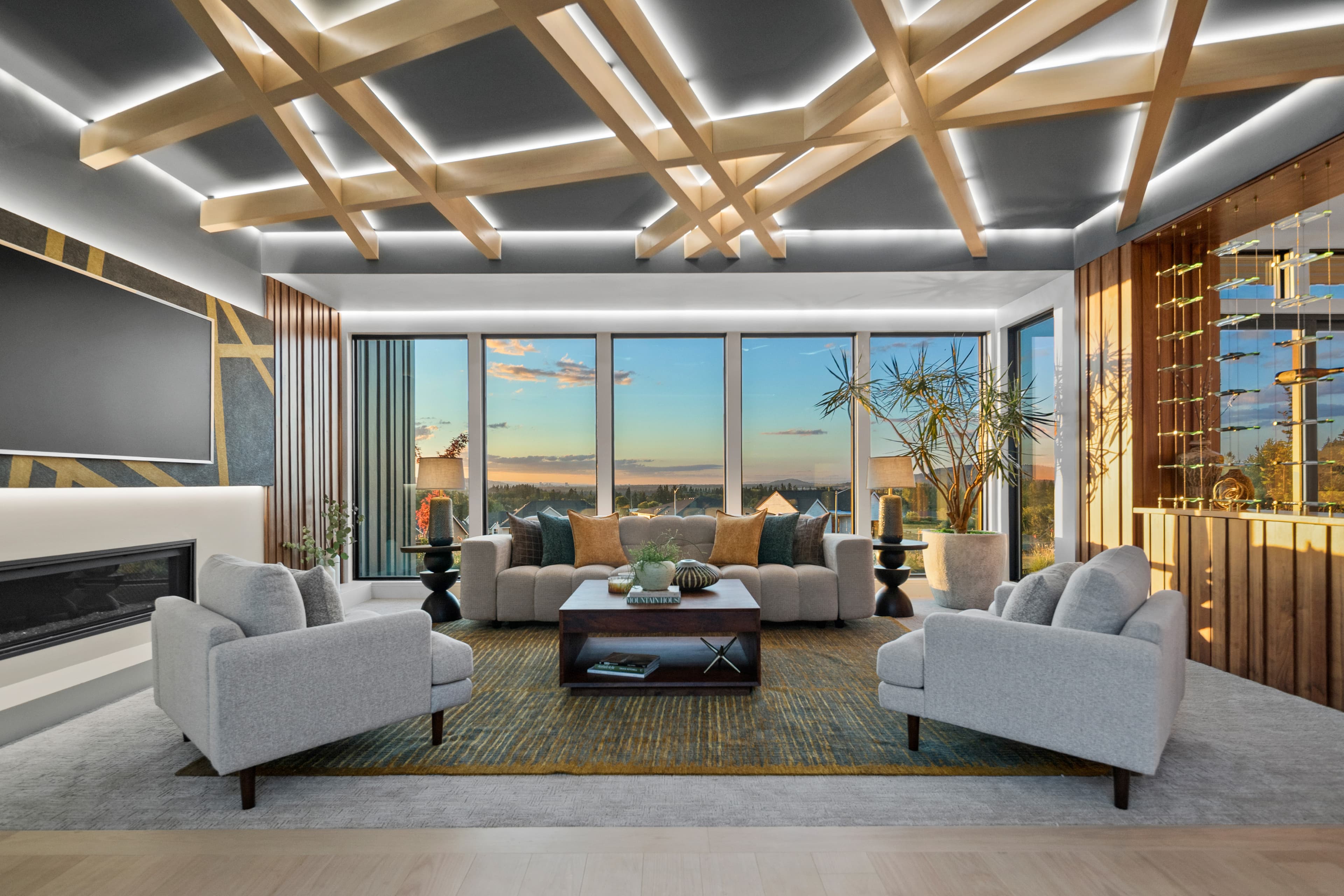 Great room of the Creekside Homes Street of Dreams house at dusk — wood-slat ceiling, walls of glass, and wine-country views