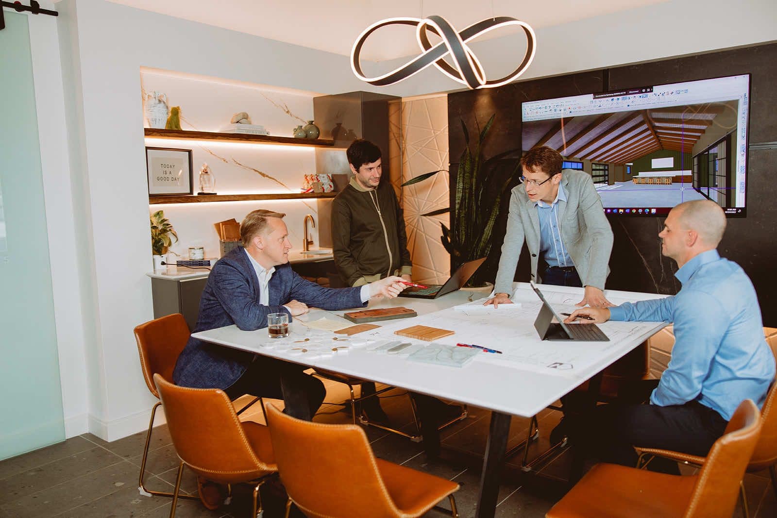 Custom home builder team in design consultation with blueprints and 3D rendering